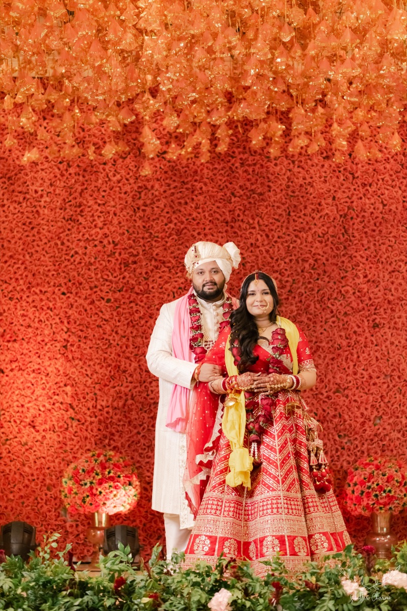Couple against a rose wall in Goa