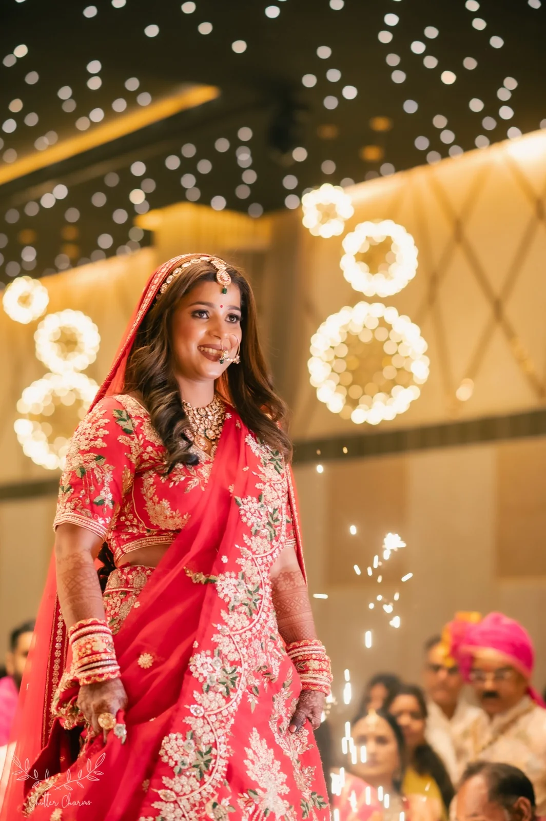 Smiling bride in red lehenga making her grand wedding entry