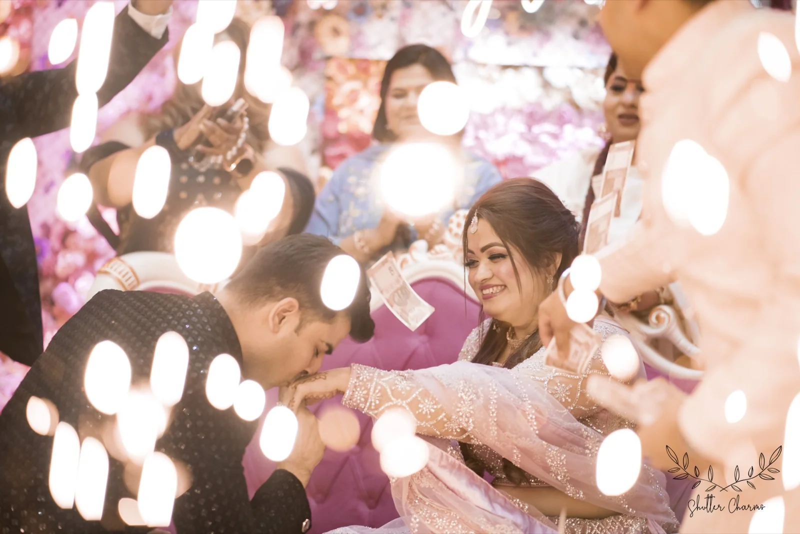 Groom kisses bride's hand during sparkling ring ceremony celebrations