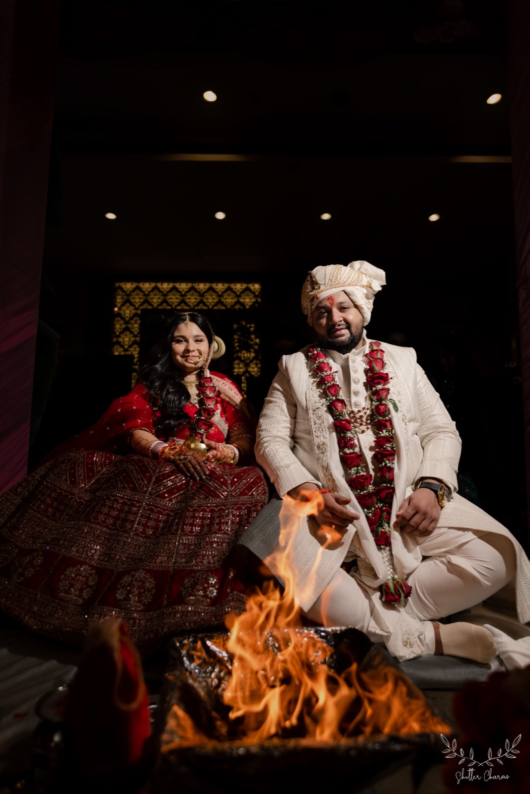 Bride and groom smiling beside the sacred fire during pheras