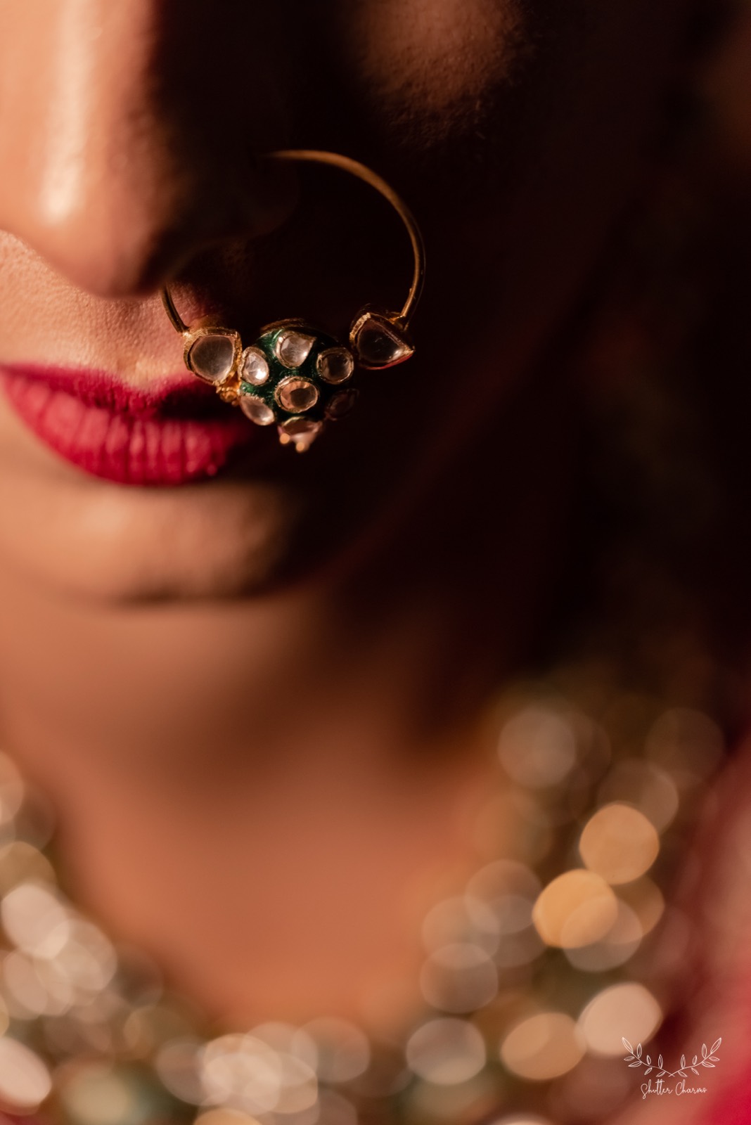 Close-up of bride's kundan nose ring and red lips