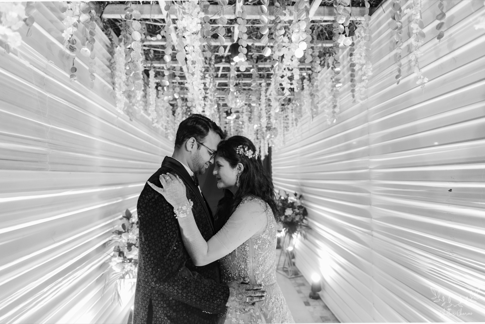 Couple embracing forehead to forehead under shimmering hanging decor
