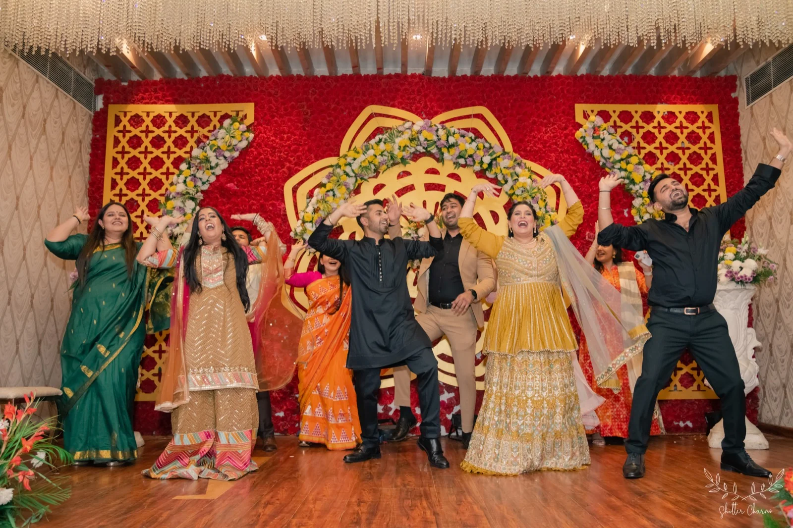 Family performing a choreographed sangeet dance on a decorated stage